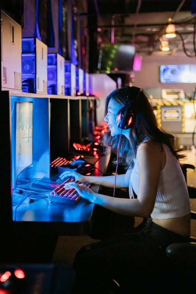 pexels-photo-7915440-7915440 A woman intensely focused on a gaming computer in an esports setting with vibrant lighting.