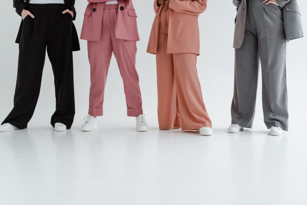 Fashionable women in stylish suits posing indoors on a white background.